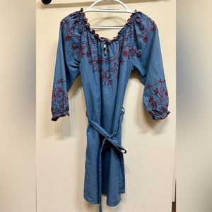 Blue denim dress with red stitching.